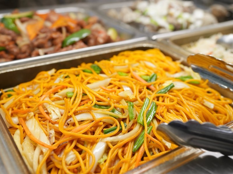 Lo mein noodles with cabbage, carrots and green onions on the buffet line