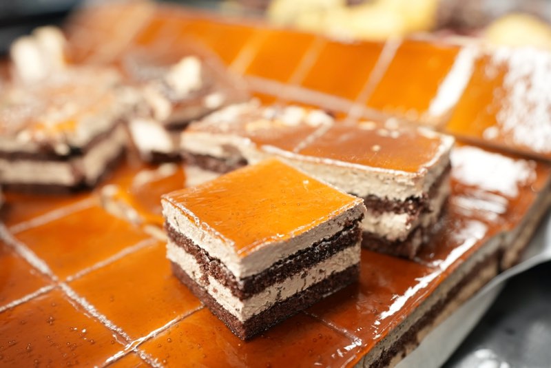 Layered caramel and chocolate mousse cake squares on the dessert bar