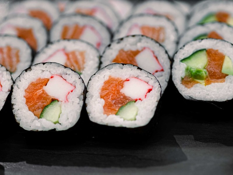 Close-up of sushi rolls with salmon, crab, cucumber and avocado